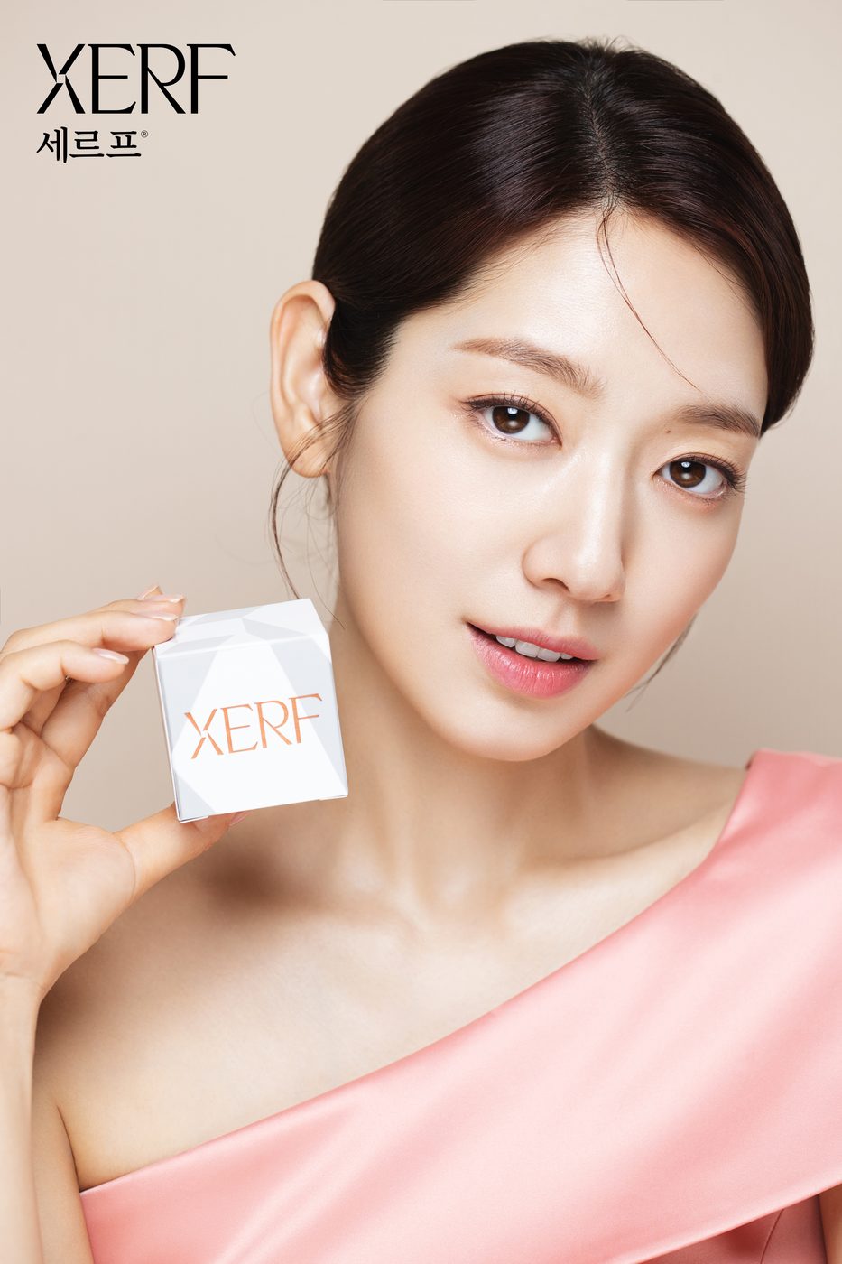 XERFエフェクターの箱を持つ、ピンクのドレス姿のモデル パク・シネさんの写真